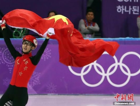 2月22日，在平昌短道速滑男子500米决赛中，中国选手武大靖夺得金牌。图为武大靖手举五星红旗庆祝胜利。中新社记者 宋吉河 摄