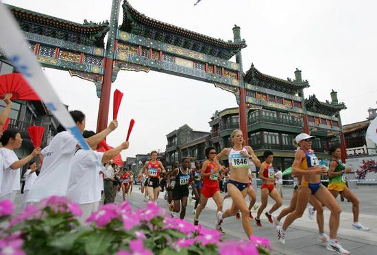 2008年北京女子马拉松决赛，选手们跑过前门大街。视觉中国图片